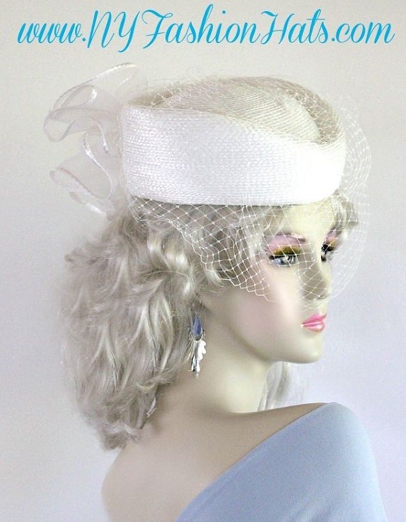 Ladies White Designer Pillbox Fashion Wedding Bridal Hat With A Bow And Birdcage Face Veil. This Formal Pillbox Hat Is Suited For A Bride, Mother Of The Bride Or Groom, Church, Garden Tea Parties, Formals, Horse Races, And Special Occasion.