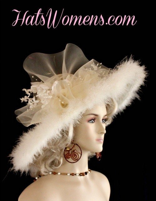Ladies Avant Garde Haute Couture Sheer Straw Braid And Crinoline Wide Brim Formal Fashion Hat. This Custom Made Women's Designer Hat Is Embellished With A Large Sheer Ivory Crinoline Bow, Accented With Ivory Velvet And Silk Flowers, Adorned With Sequin And Shooting Pearls. A Stunning Marabou Feather Trim Encircles The Wide Brim Of This Ladies Dress Hat. This Beautiful Designer Hat Is Suited For A Bride To Be On Her Wedding Day, Horse Races, The Kentucky Derby, Church, Weddings, Formals, And Special Occasion. This Fashion Hat Is Custom Made By Women's Hats, hatswomens.com.